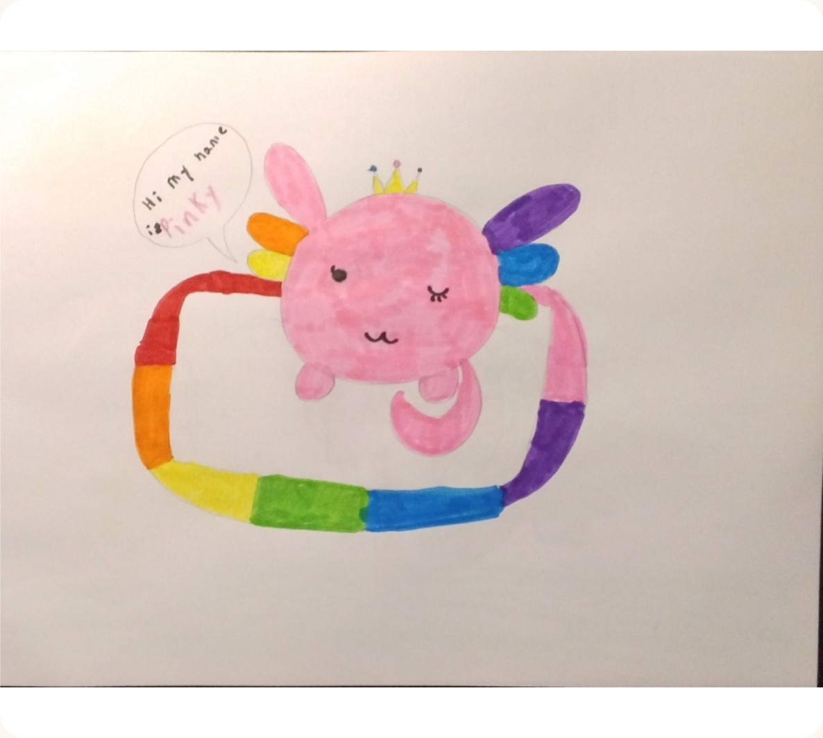 A child's felt-tip drawing of a pink axolotl wearing a crown, inside a rainbow border